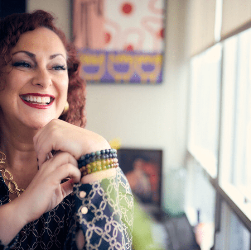 Woman wearing patterned blouse and bracelets